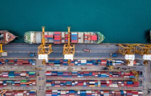 Top view of international port with Crane loading containers in import export business logistics.