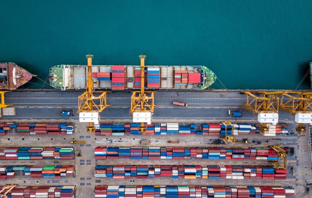 Top view of international port with Crane loading containers in import export business logistics.