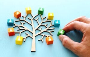 Business image of wooden tree with people icons over blue table