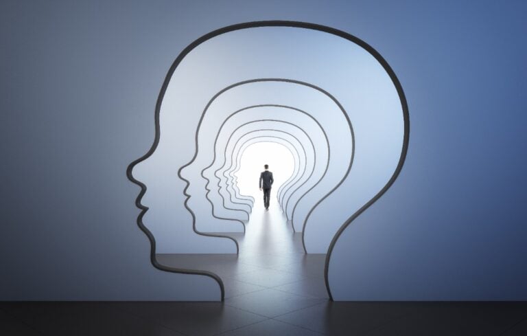 back view walking businessman to the light spot in corridor with walls in form of human head