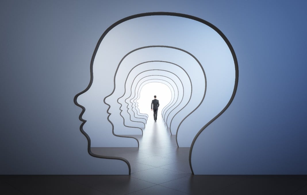 back view walking businessman to the light spot in corridor with walls in form of human head