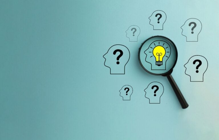 Magnify focus on Head with glowing light bulb icon among Head with Question mark icon over blue background