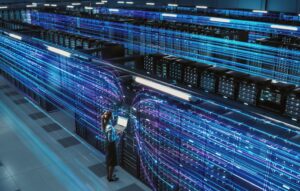 Big Data Center Female Chief Technology Officer Using Laptop Standing In Warehouse